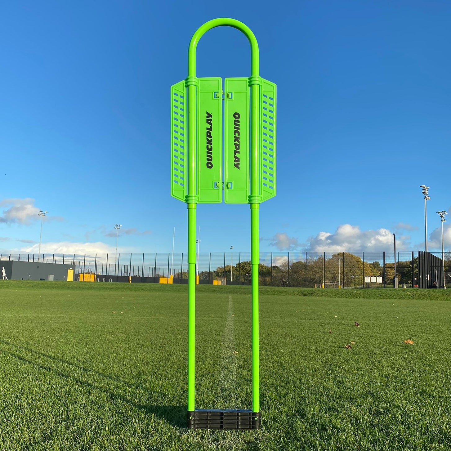 REPLAY Defender Mannequin standing upright on a grass field: a green frame with QUICKPLAY side panels and a black base.