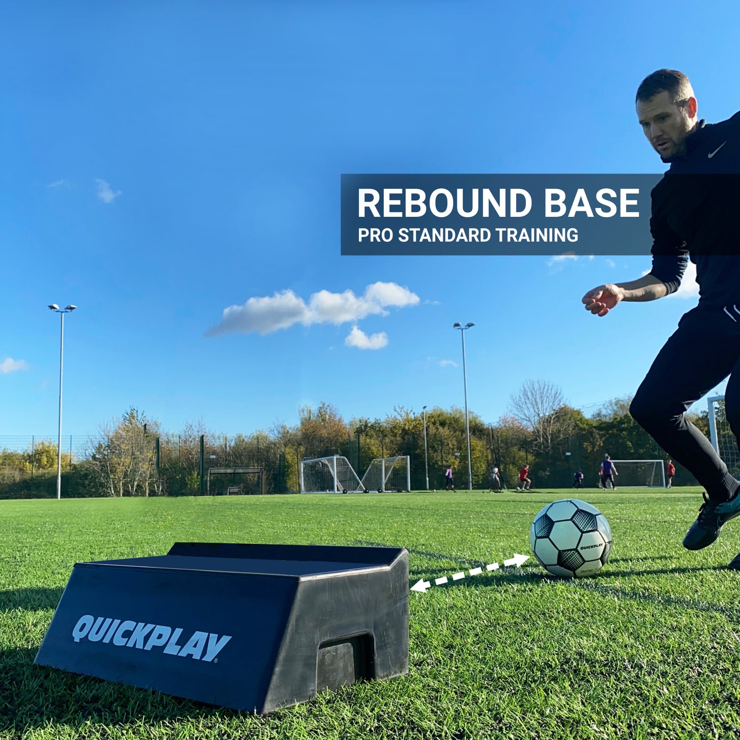 Player passing a soccer ball into the REPLAY Block Dual Angle Rebound Board on an artificial field, with the text "Rebound base".