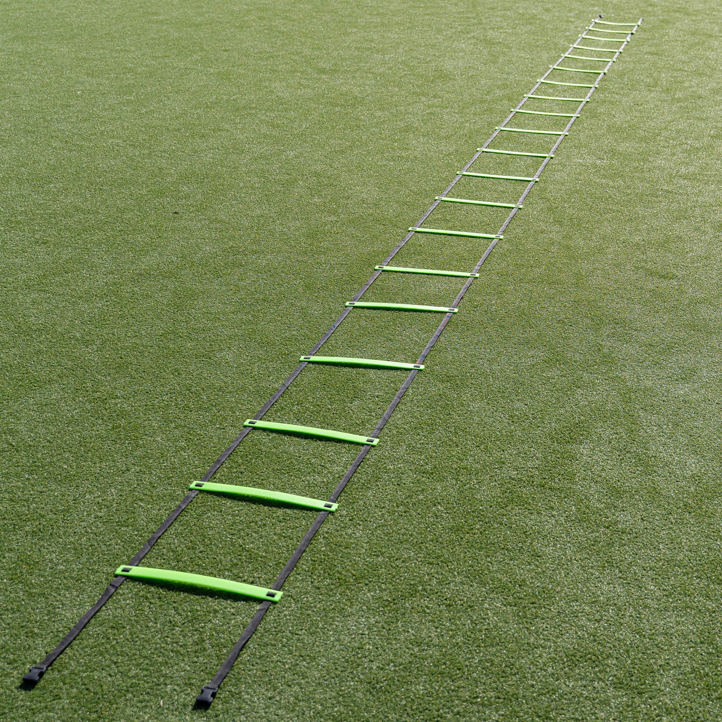 Agility Ladder XXL 30ft laid out straight on artificial turf, the green rungs stretching into the distance.