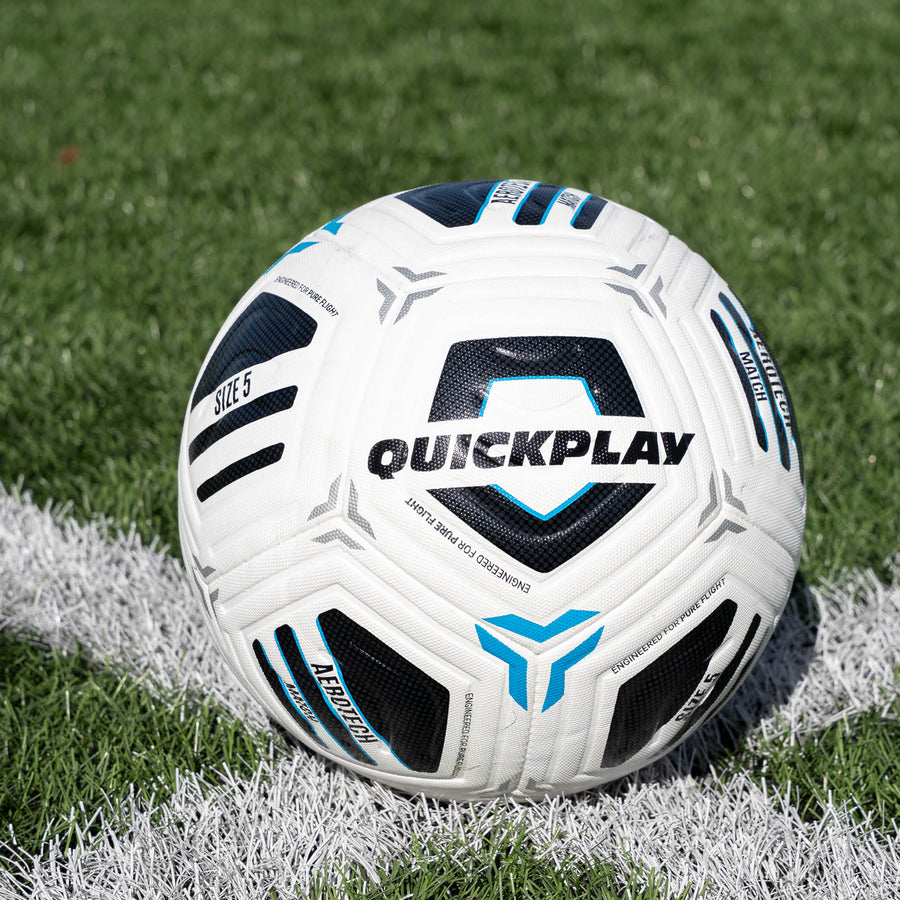 White Aerotech Match  soccer ball with blue and black accents on a grass field, featuring the brand 'Quickplay'.