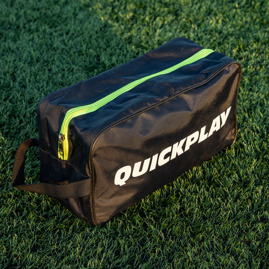 QUICKPLAY black cleat bag with green zipper on grass