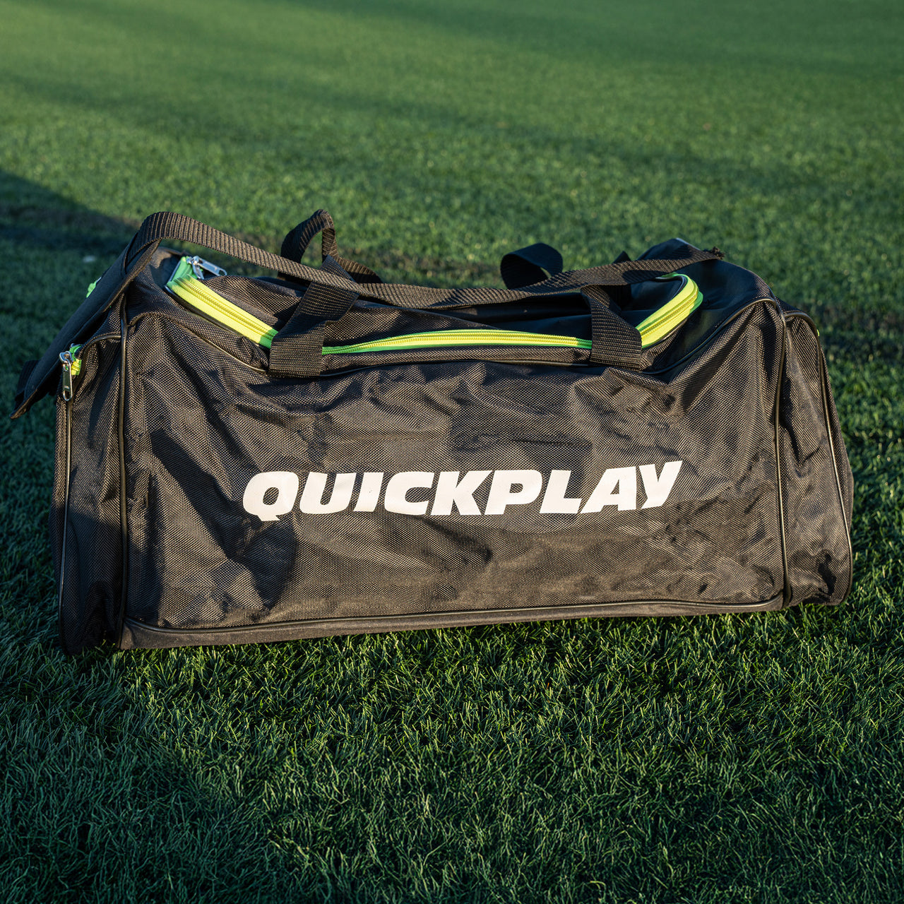 Black duffel bag with 'Quickplay' branding on grass