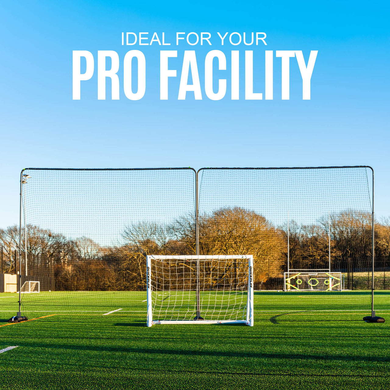 Soccer goal and extended barrier net on a grass field with clear blue sky