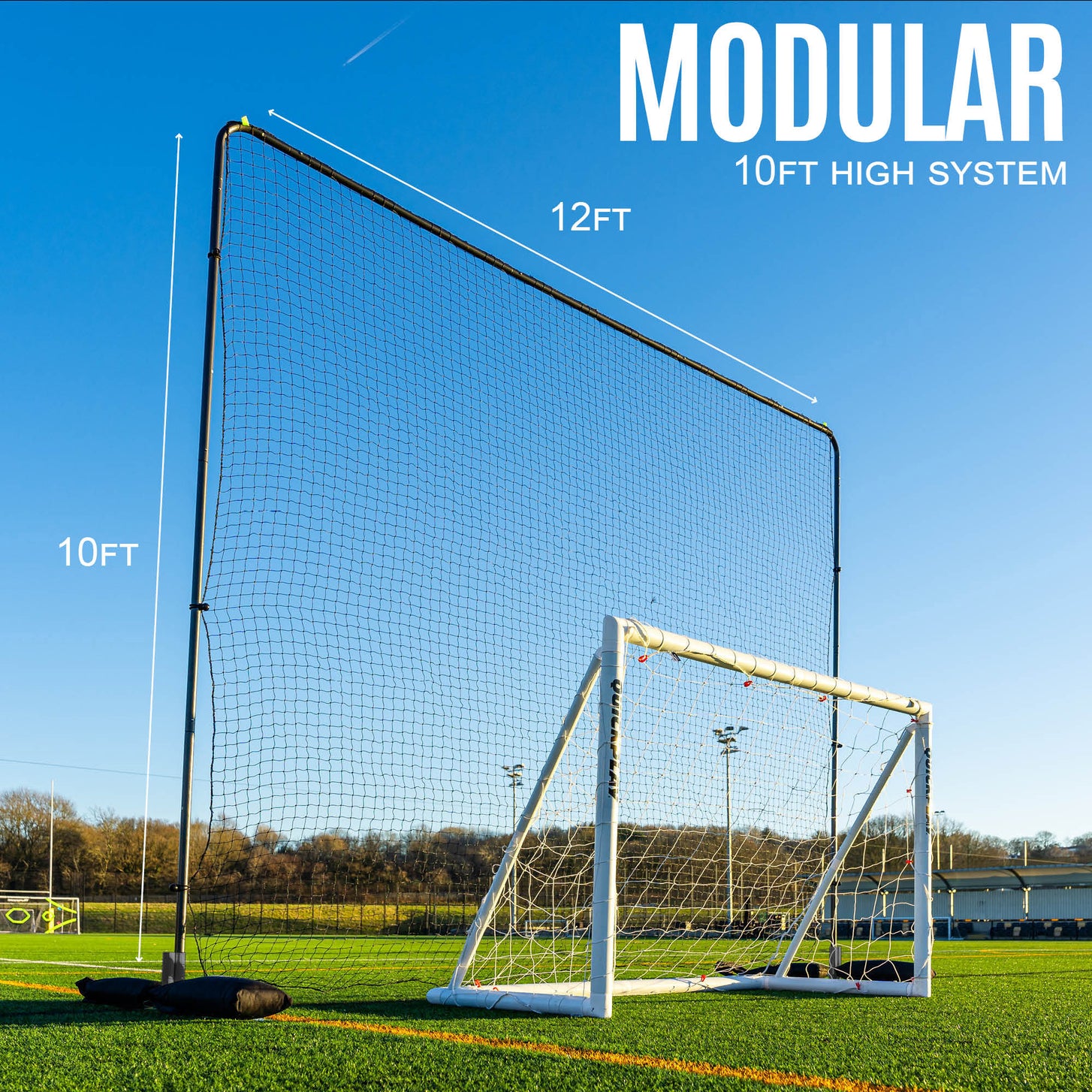 10ft Barrier Net System Freestanding: one panel behind a white goal on an artificial field, marked 12ft wide and 10ft high, with the text "Modular".