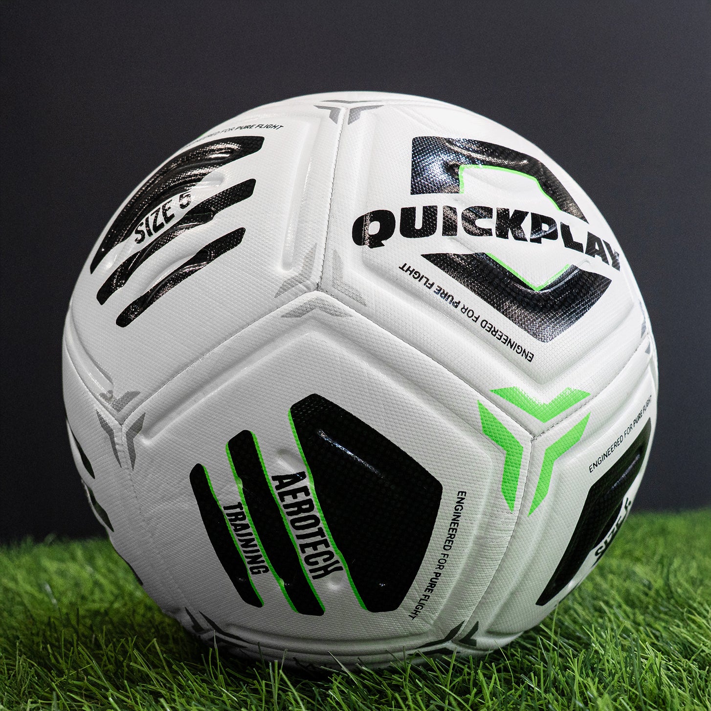 White Aerotech soccer ball with black and green branding on a grassy field