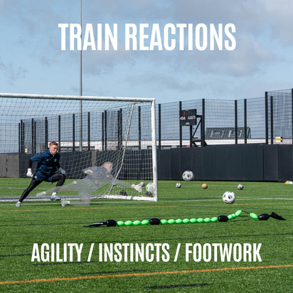 goalkeeper practicing soccer on a field with a goal and QUICKPLAY goalkeeper deflection line.
