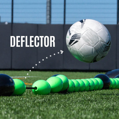 Person setting up a goalkeeper deflection line on a grass field with stadium in the background