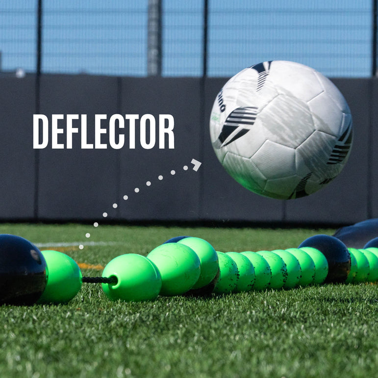 Person setting up a goalkeeper deflection line on a grass field with stadium in the background