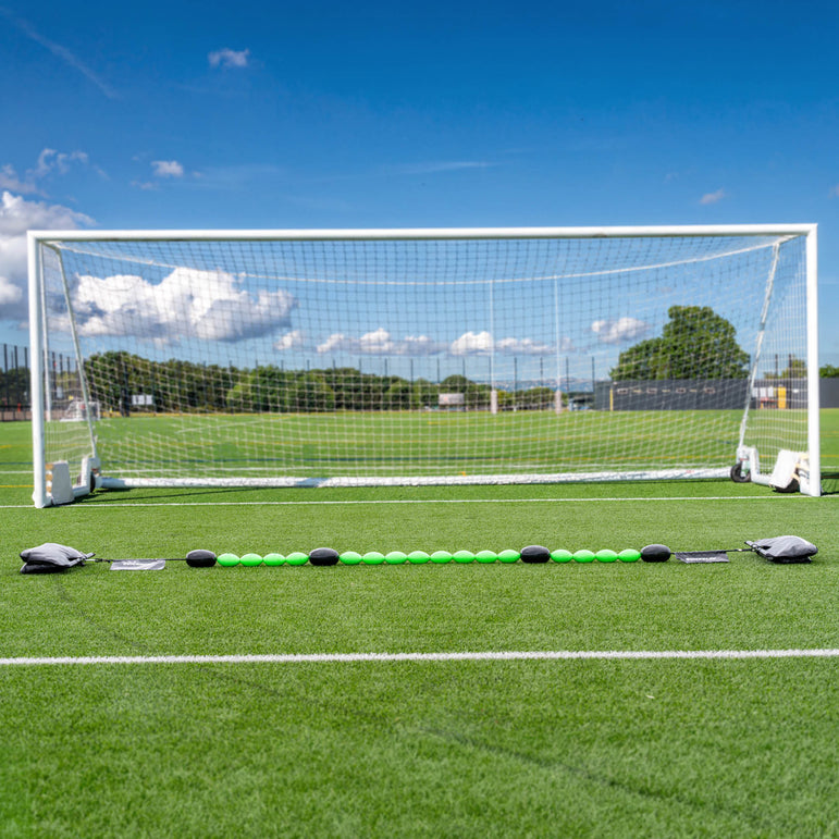 Long line of a green goalkeeper deflection line on grass
