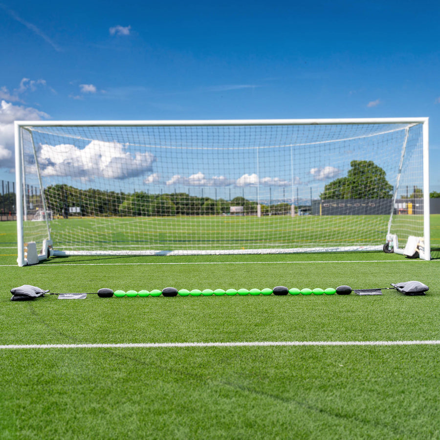 Long line of a green goalkeeper deflection line on grass
