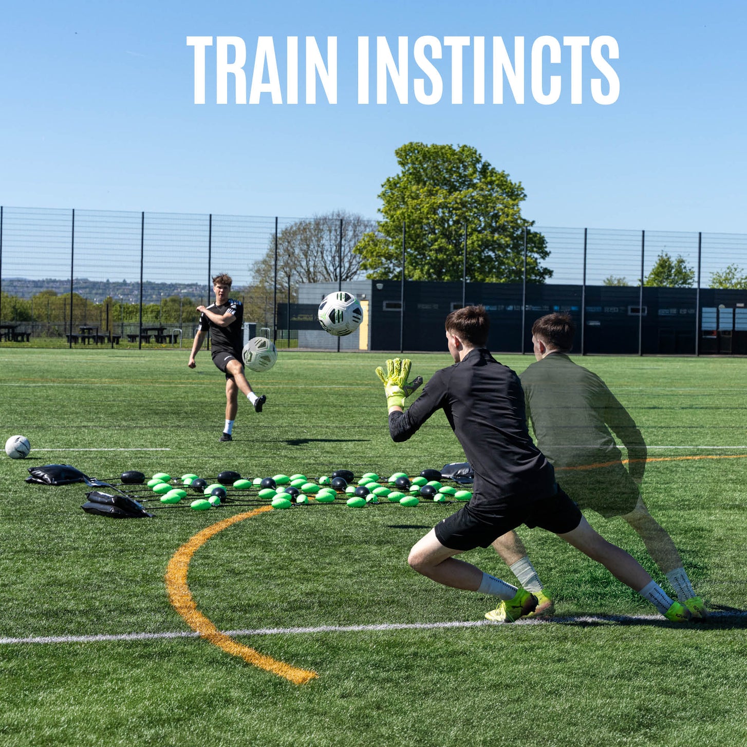 Player shooting at a goalkeeper set behind the Goalkeeper Ball Deflection Floor Grid on an artificial field, with the text "Train instincts".