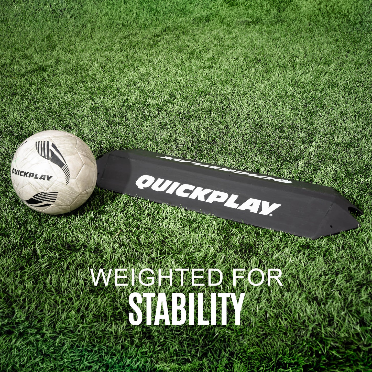 Goalkeeper Deflection Ramp lying on grass beside a white QUICKPLAY soccer ball, with the text "Weighted for stability".
