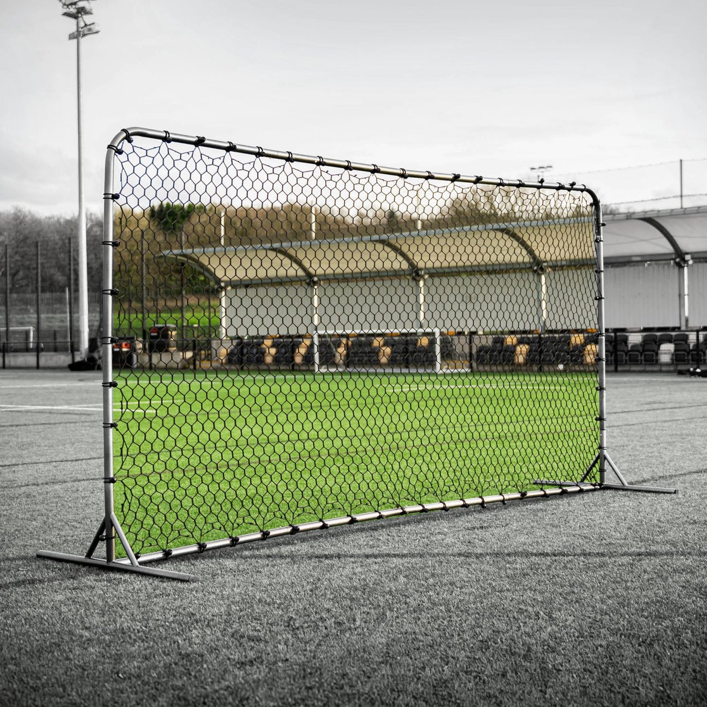 GS Rebound Wall 12x6' with its black net fitted to the gray frame, standing on an artificial field.