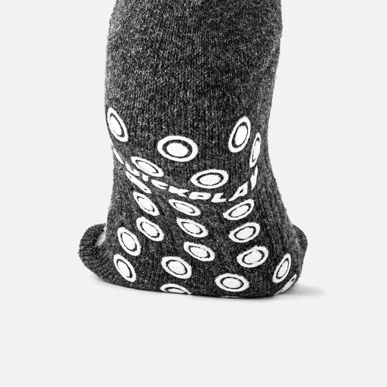 Gray sock with white grip pattern on a light gray background