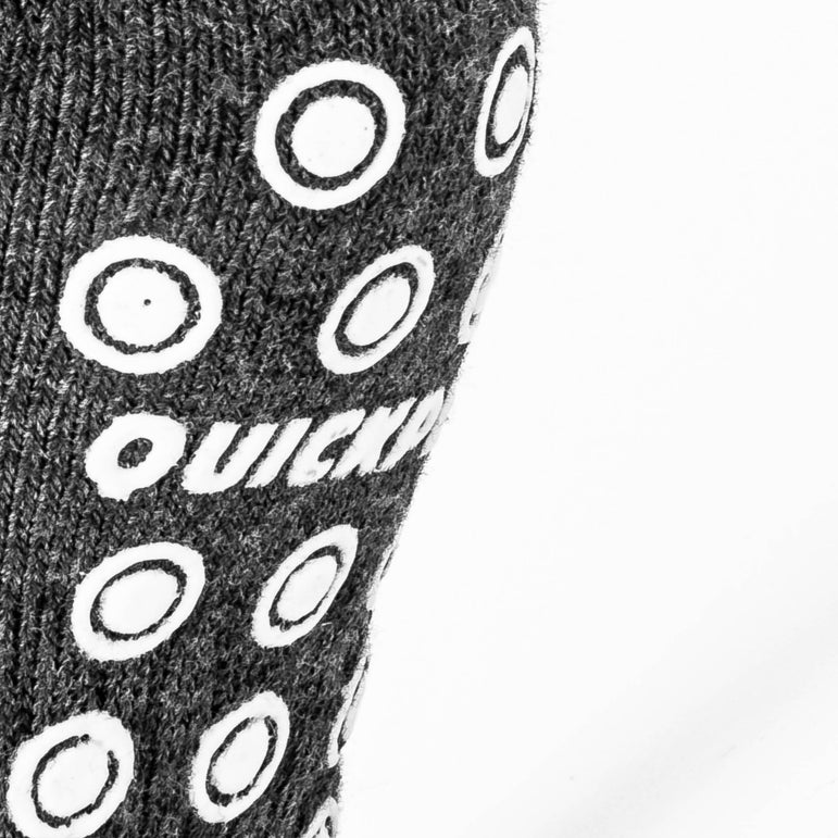 Close-up of a sock with circular grip patterns and QUICKPLAY branding on a gray background