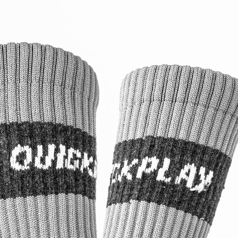 Gray socks with black and white QUICKPLAY branding on a white background