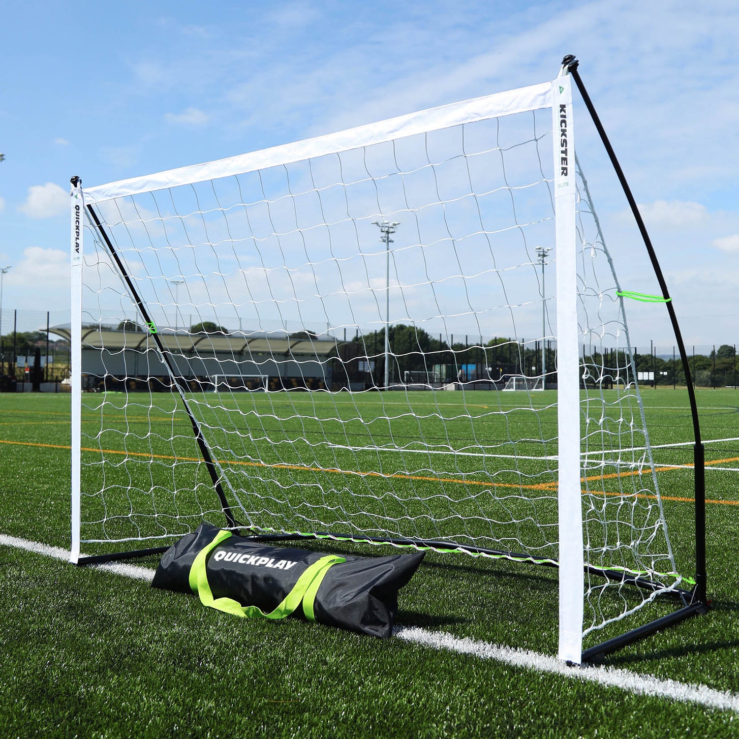 KICKSTER Elite 6x4' goal on an artificial field from a front corner, with its black QUICKPLAY bag lying in front.