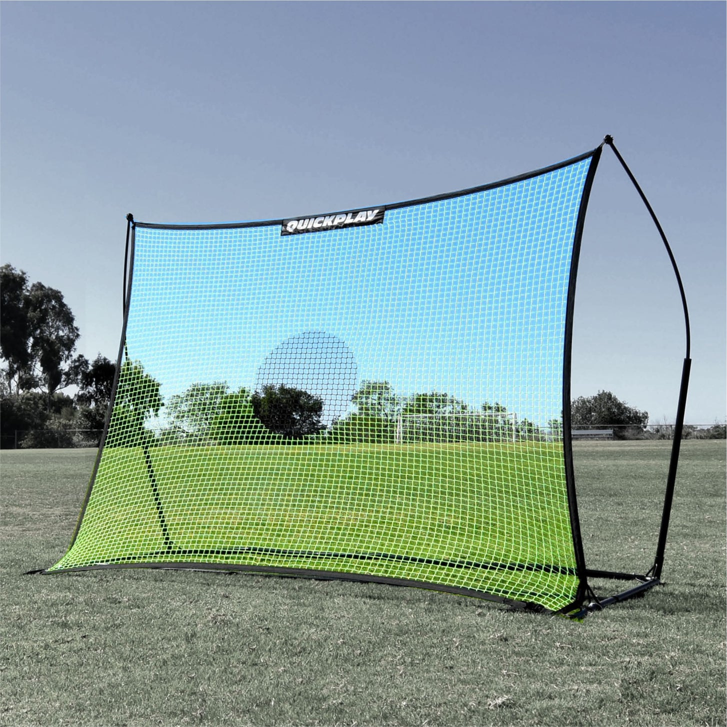 TEKKERS Net XL 8x6' green net fitted to a black curved-frame rebounder on a grass field.