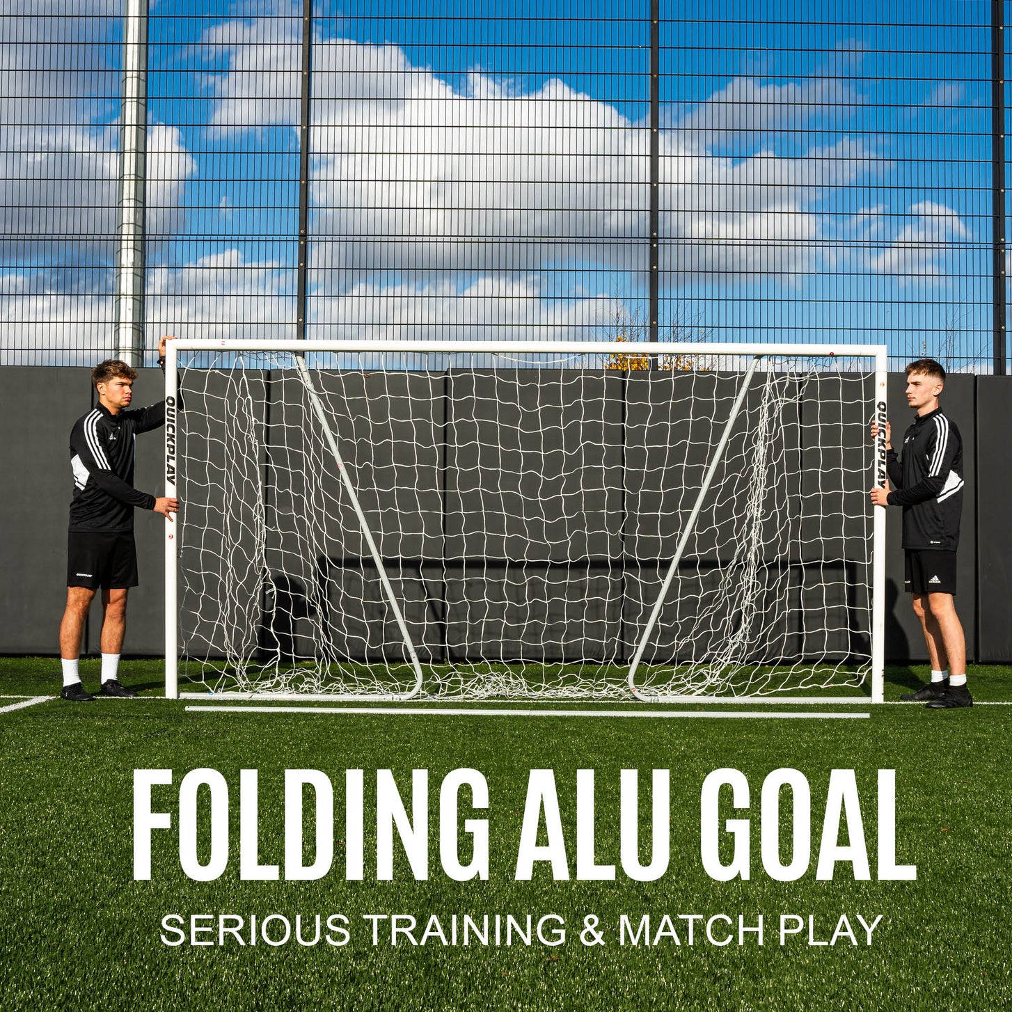 PRO ALU Match60 12x6' goal held upright by two players on artificial turf in front of a fence, with the text "Folding ALU goal, serious training & match play".