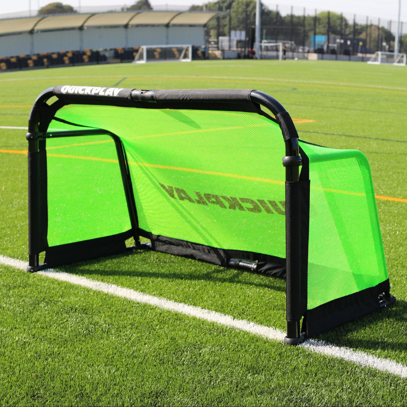 PRO ALU Training Soccer Goal 6x4' with a black frame and green net standing on the white line of an artificial field.