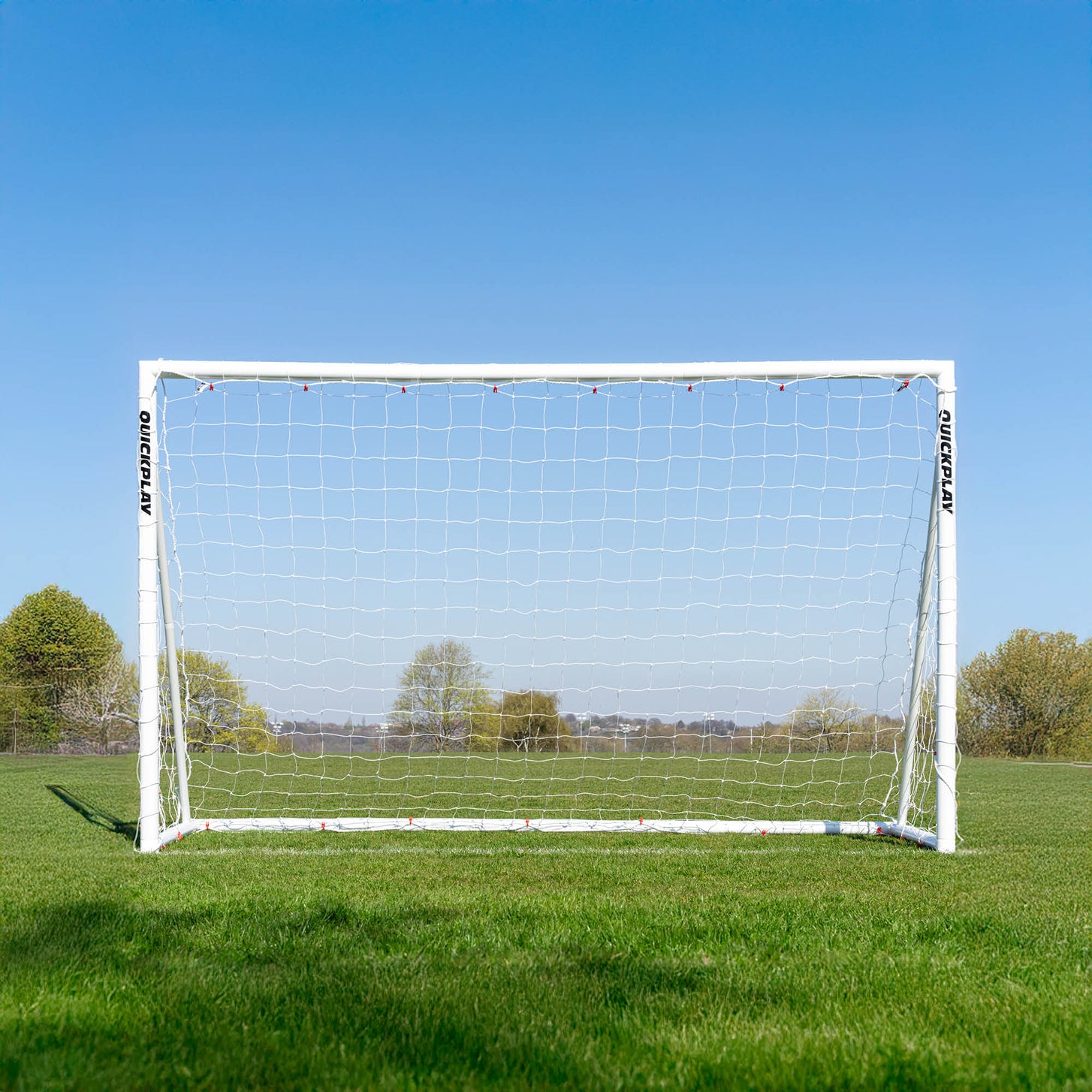 Q-FOLD 10x6' goal from the front on a grass field under a clear blue sky.
