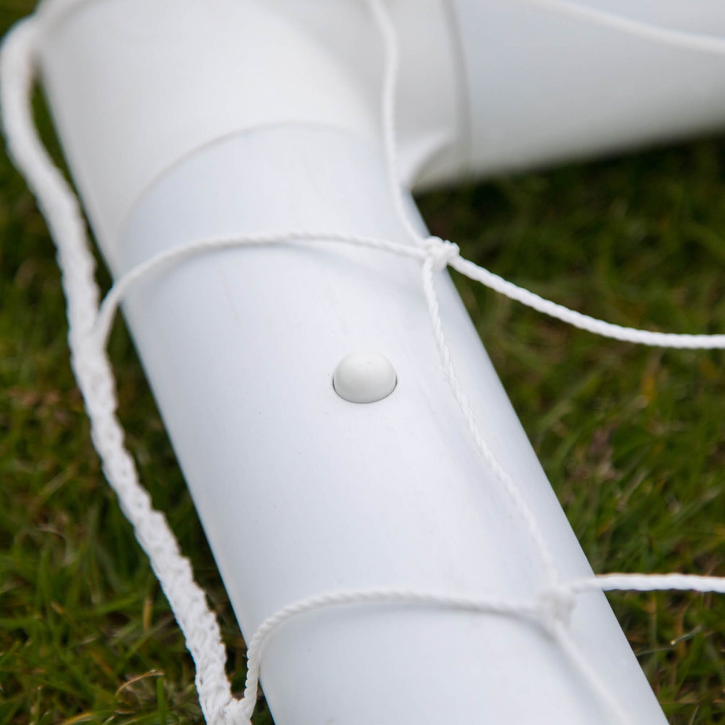 Q-FOLD Mini 3x2.5' frame tube close up showing a white button and the net cord tied around it.