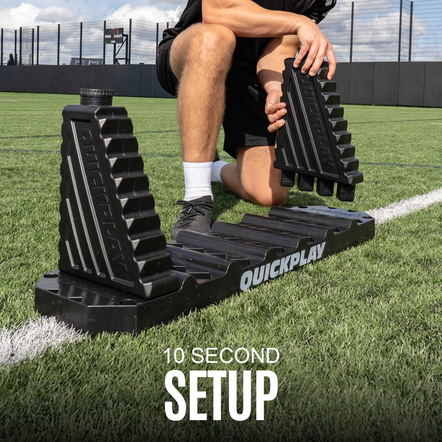 Person using a black rebound board on a grass field with 'QuickPlay' branding.