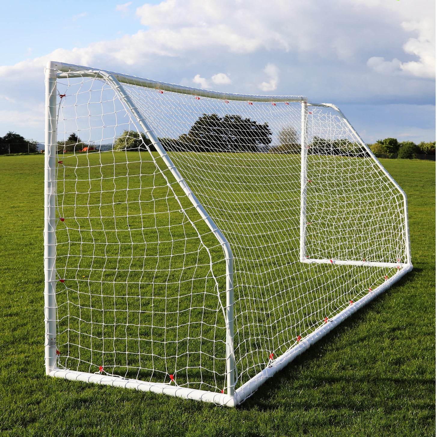 Q-FOLD Match 16x7' goal from a rear corner on a grass field, showing the net depth and back frame.