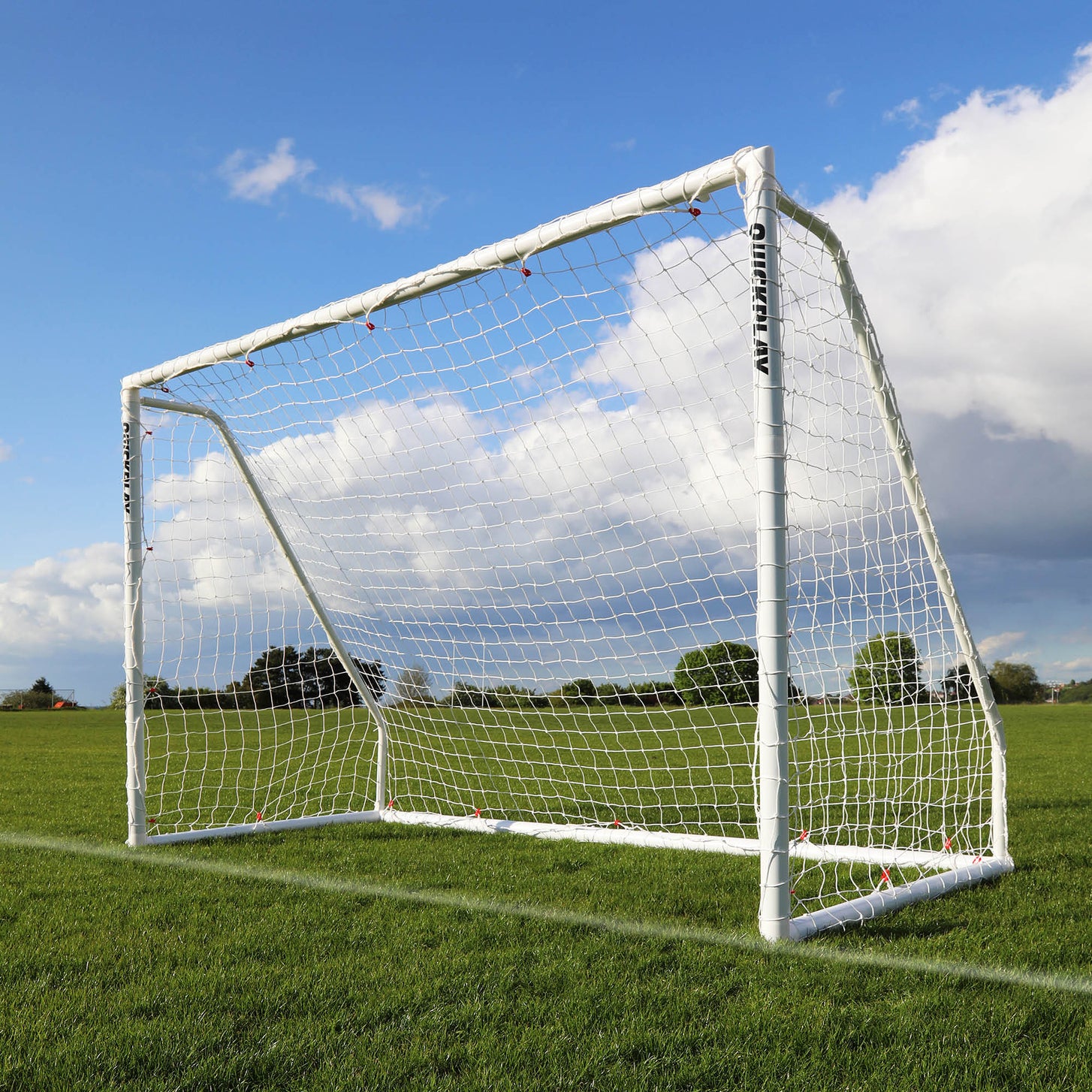 QUICKPLAY Q-FOLD Soccer goal on a grass field with a blue sky and clouds in the background