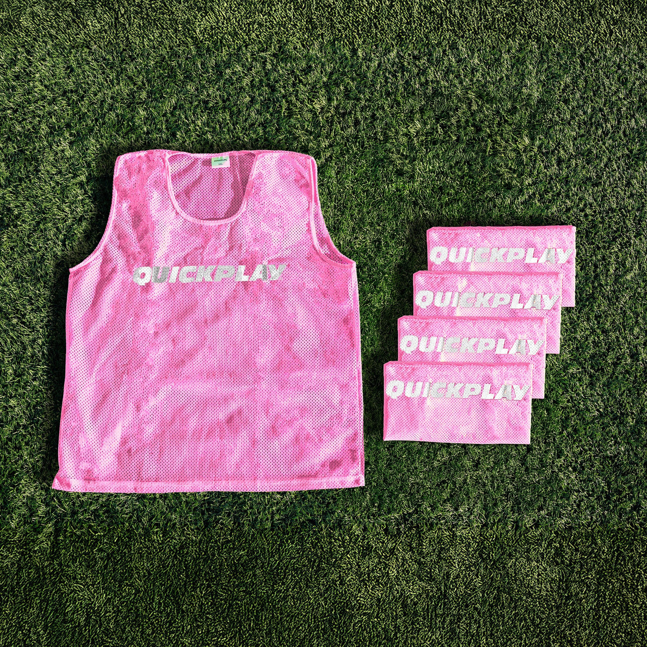 A pink QUICKPLAY breathable mesh training vest.
