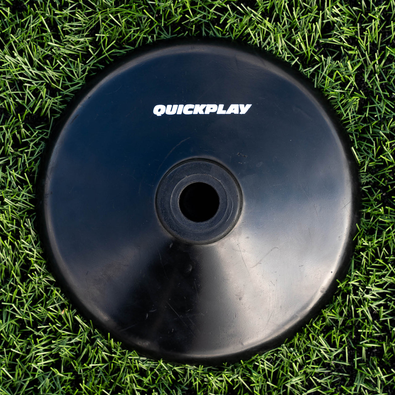 One black training pole bases with 'QuickPlay' branding on a grass field.