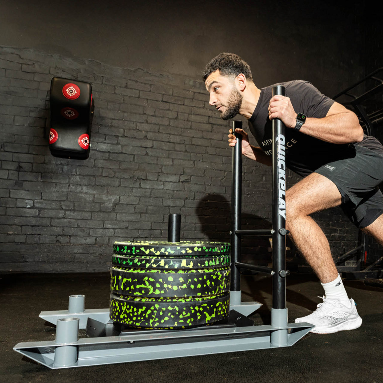 Man using a weighted push sled in a dark room