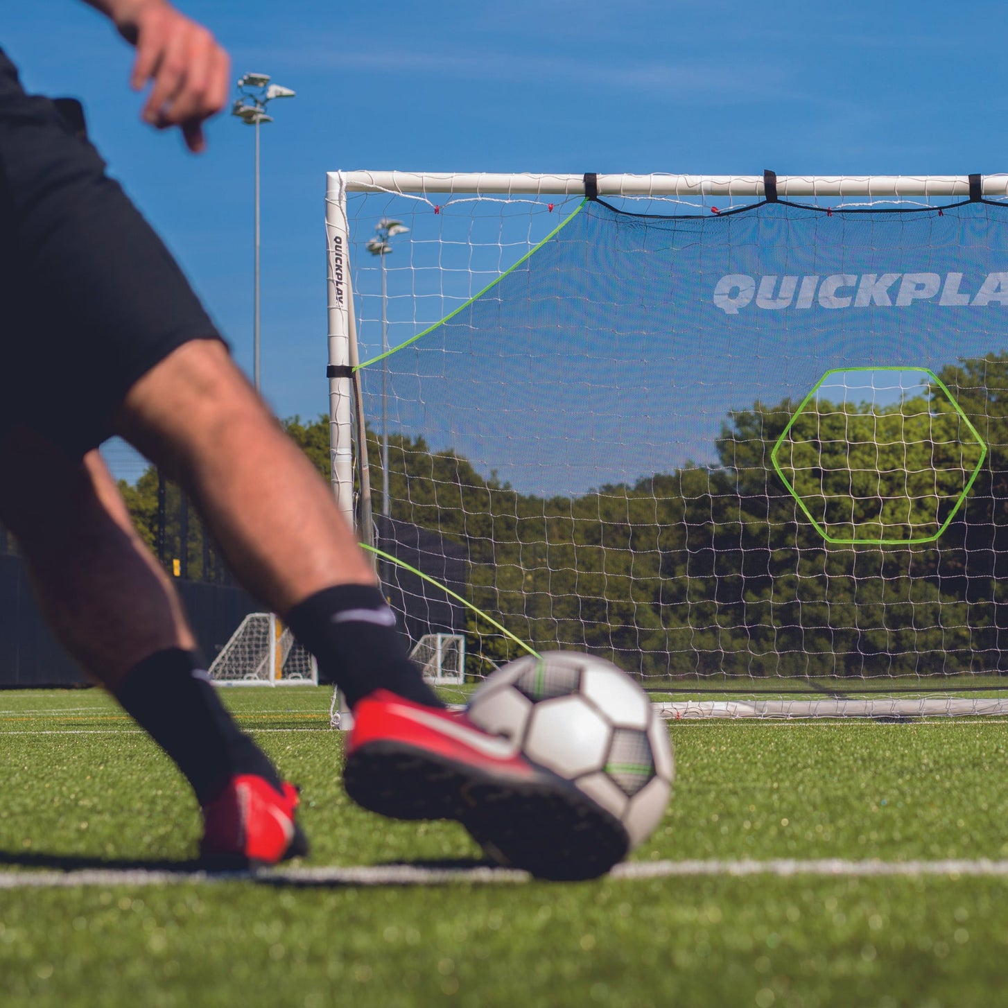 TARGET Net Lite 12x6': low view of a player's red cleat about to kick a soccer ball toward the target net