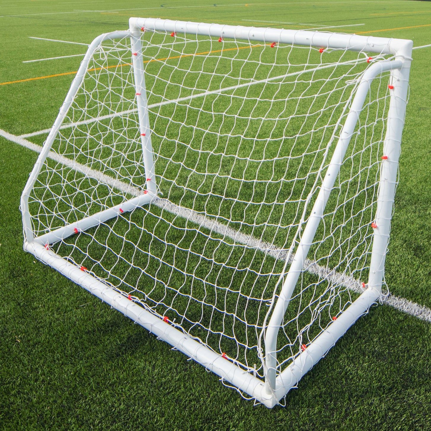Q-FOLD 6x4' goal shown with other Q-FOLD goal sizes: three white goals standing together on a grass field.