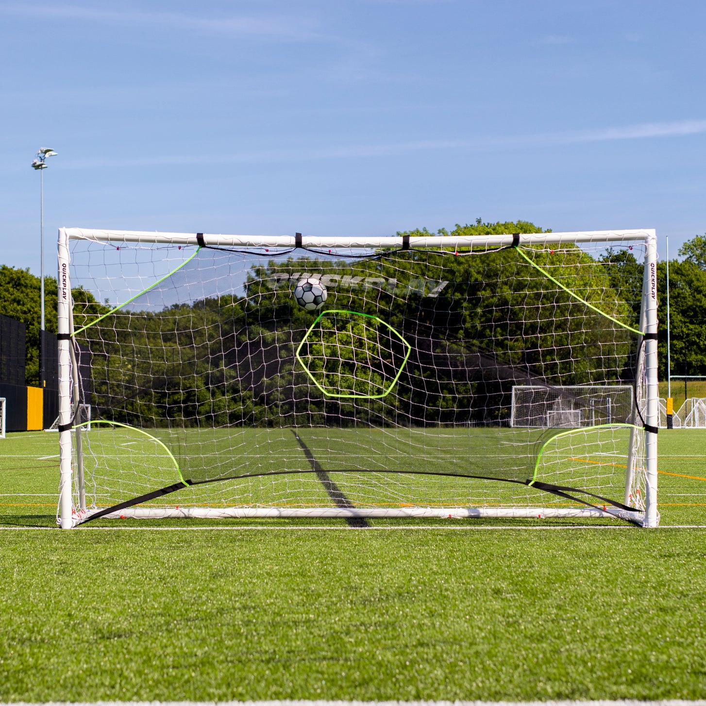 TARGET Net Lite 6x4' fitted in a white goal on an artificial field, with a ball flying in near the crossbar