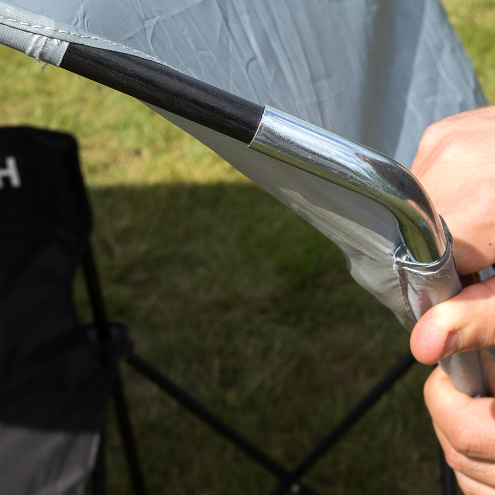 PRO Bench Shelter close-up of a hand fitting the curved metal end of a canopy pole into the gray canopy corner pocket.